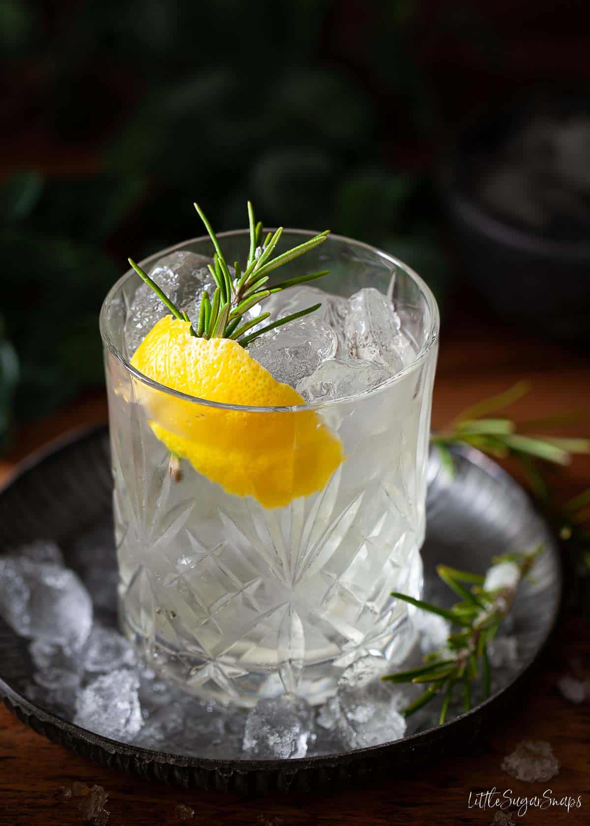 A luxardo bitter bianco cocktail with lemon and rosemary garnish.