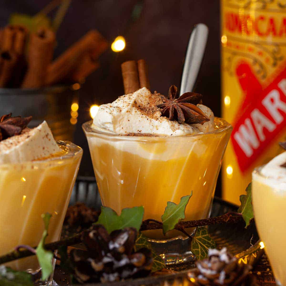 A msall glass of a bombardino drink recipe with advocaat topped with cream.
