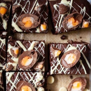 Close-up of Cadburys bcreme egg brownies topped with white chocolate drizzle and chopped mini eggs.