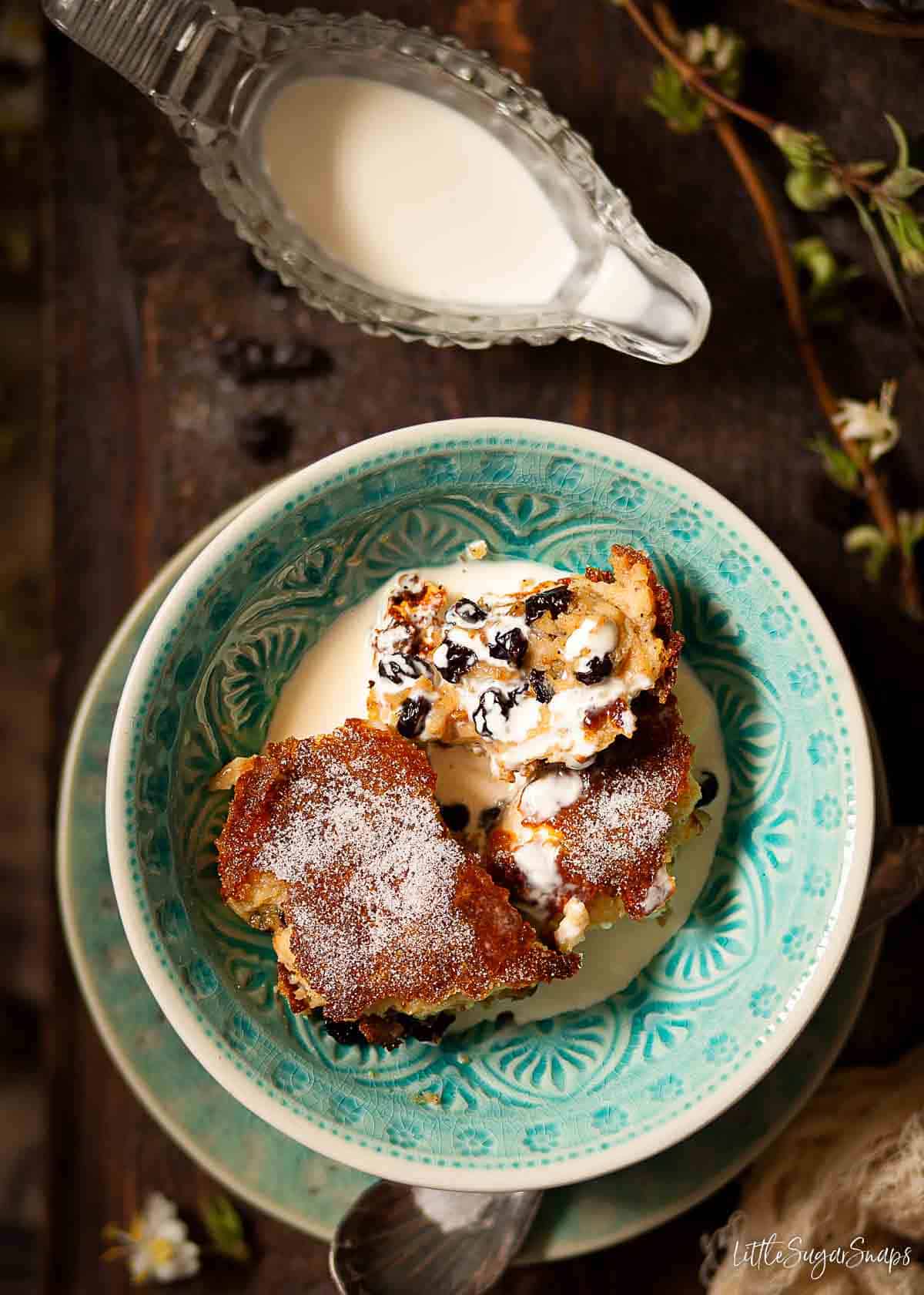 A bowl of Mansfield pudding with single cream poured over it.