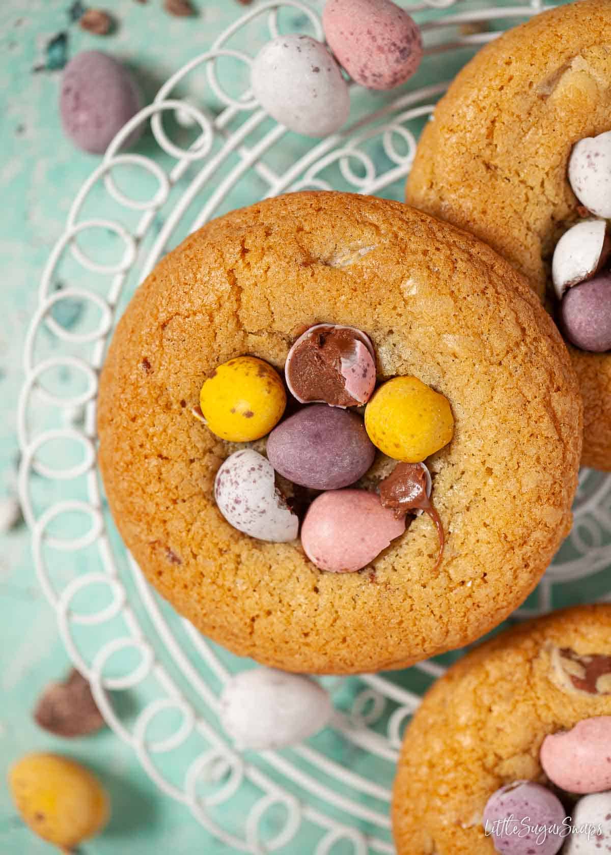 Easter Egg Cookies on a cooling rack topped wth candy chocolate eggs.