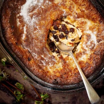 Close-up of an old-fashioned suet pudding sprinkled with caster sugar in an oval serving dish.