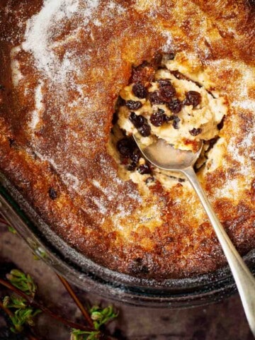 Close-up of an old-fashioned suet pudding sprinkled with caster sugar in an oval serving dish.