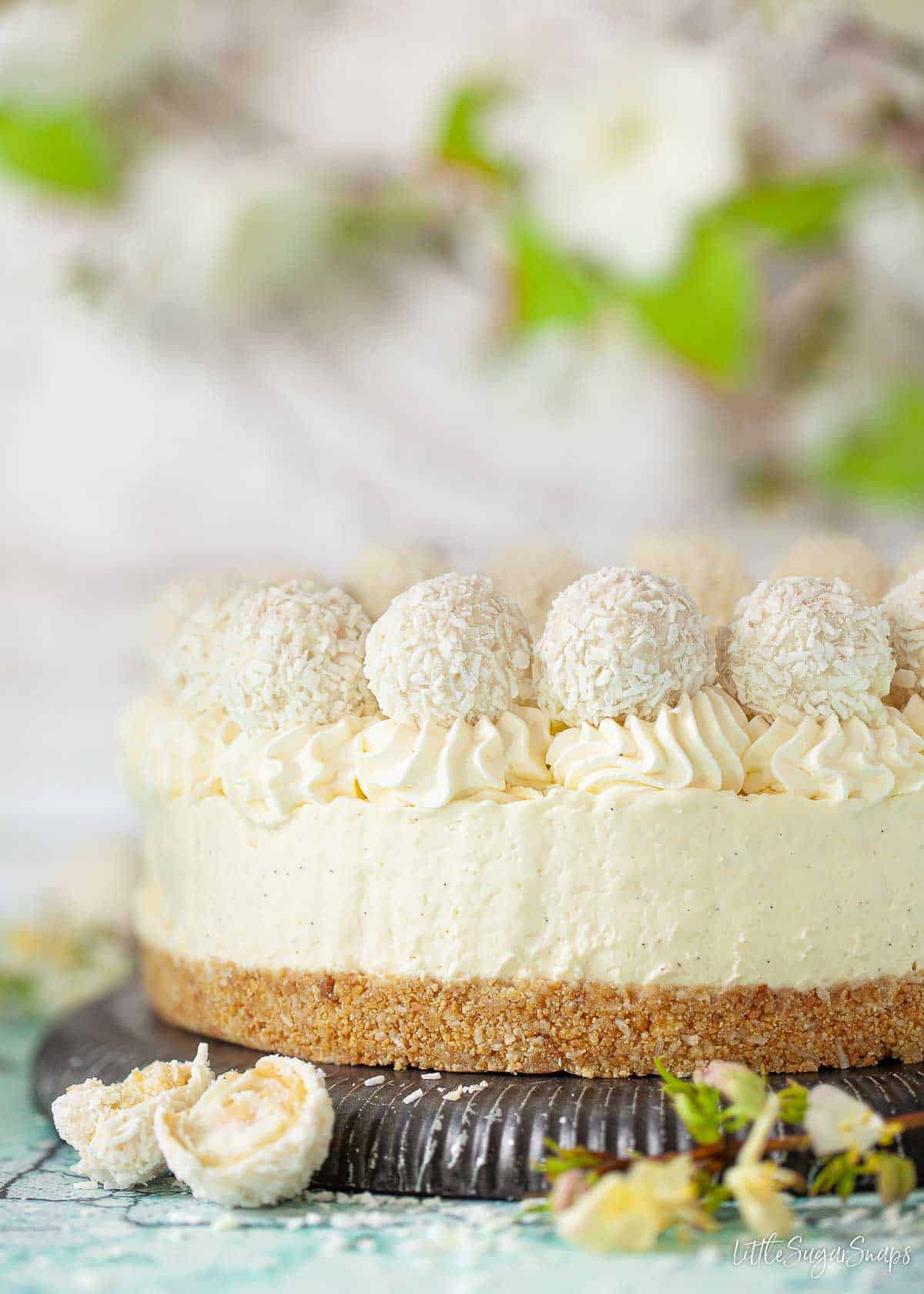 Side view of a white chocolate and coconut flavoured dessert topped with Raffaello chocolates.