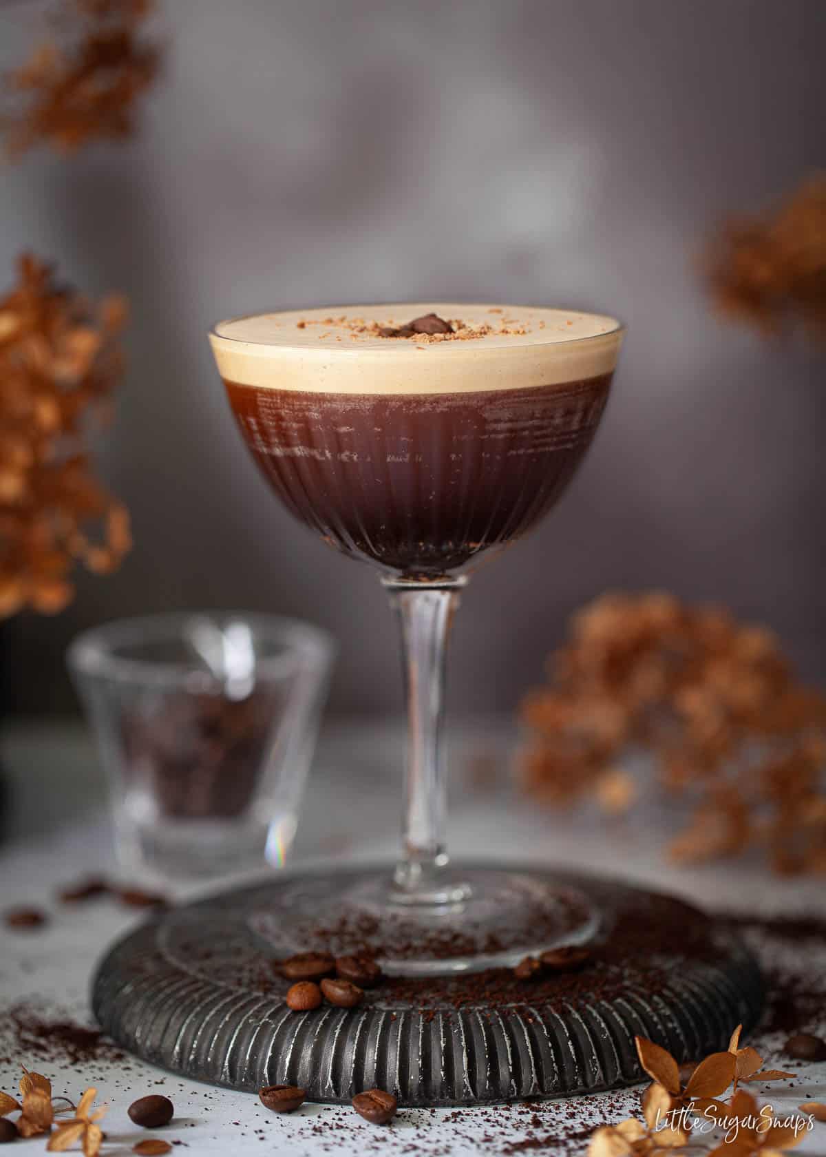 A rum espresso martini topped with grated chocolate and coffee beans.