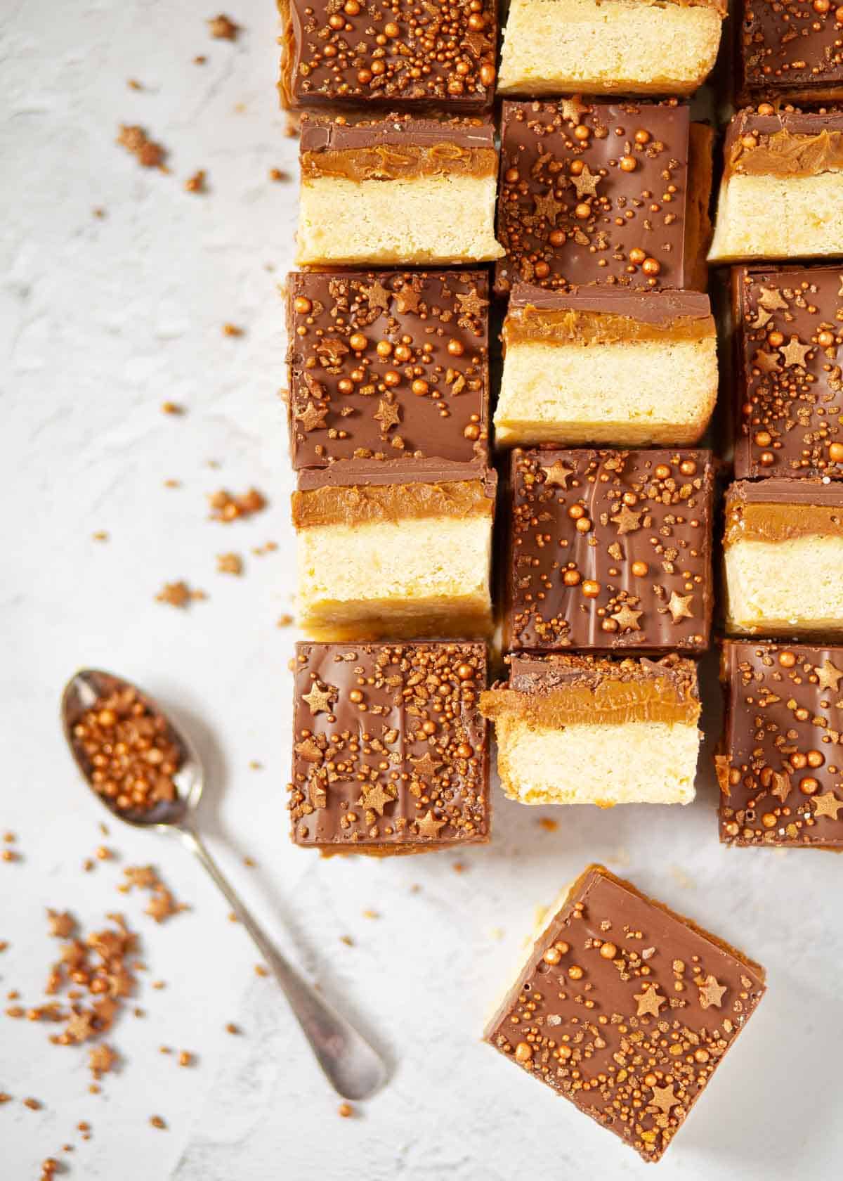 Biscoff traybake slices with a shortbread base, Biscoff spread centre and chocolate top garnished with sprinkles.