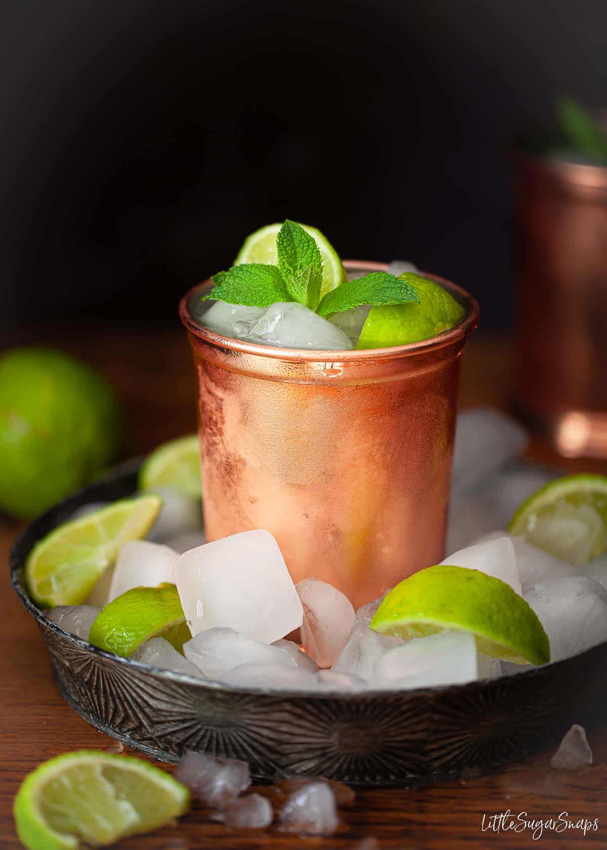 Gin buck in a copper mug in a tray loaded with ice.