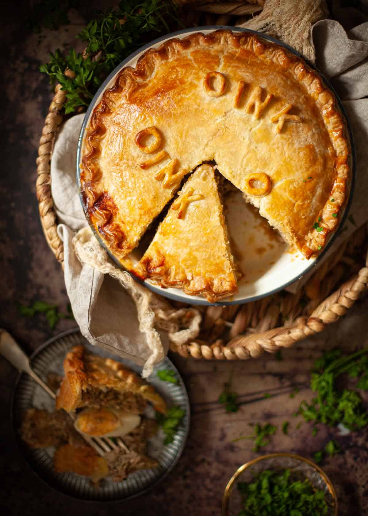A cut into sausage pie decorated pastry letters that spell oink.