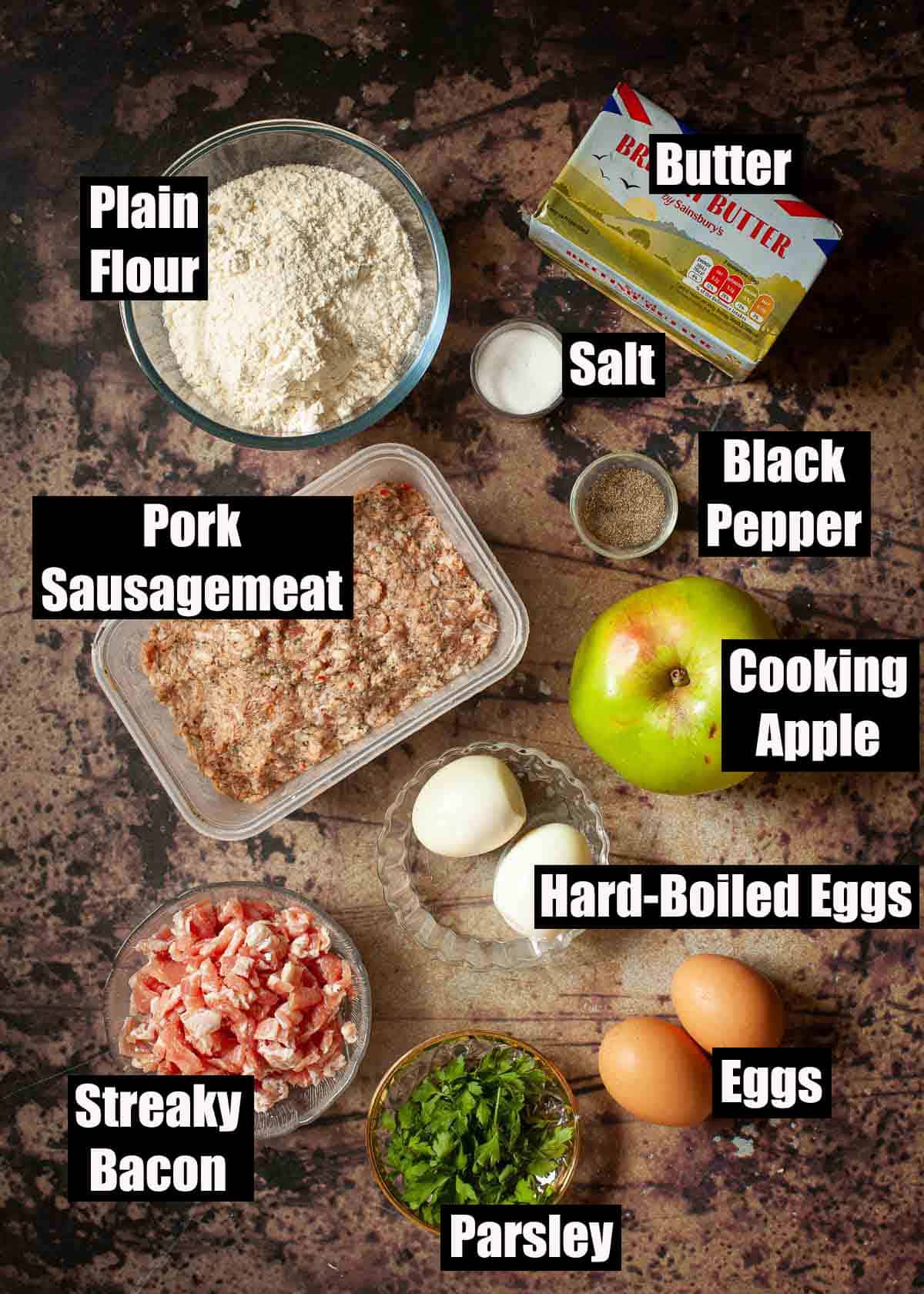 Labelled ingredients needed for a sausagemeat pie with shortcrust pastry, eggs, bacon and apple.