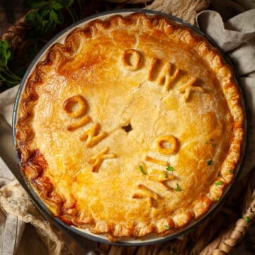 Close up of a sausage pie decorated with the word 'oink'.