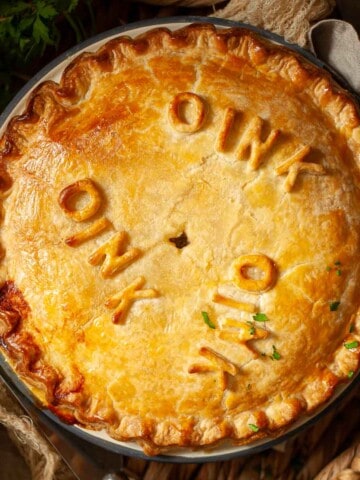 Close up of a sausage pie decorated with the word 'oink'.