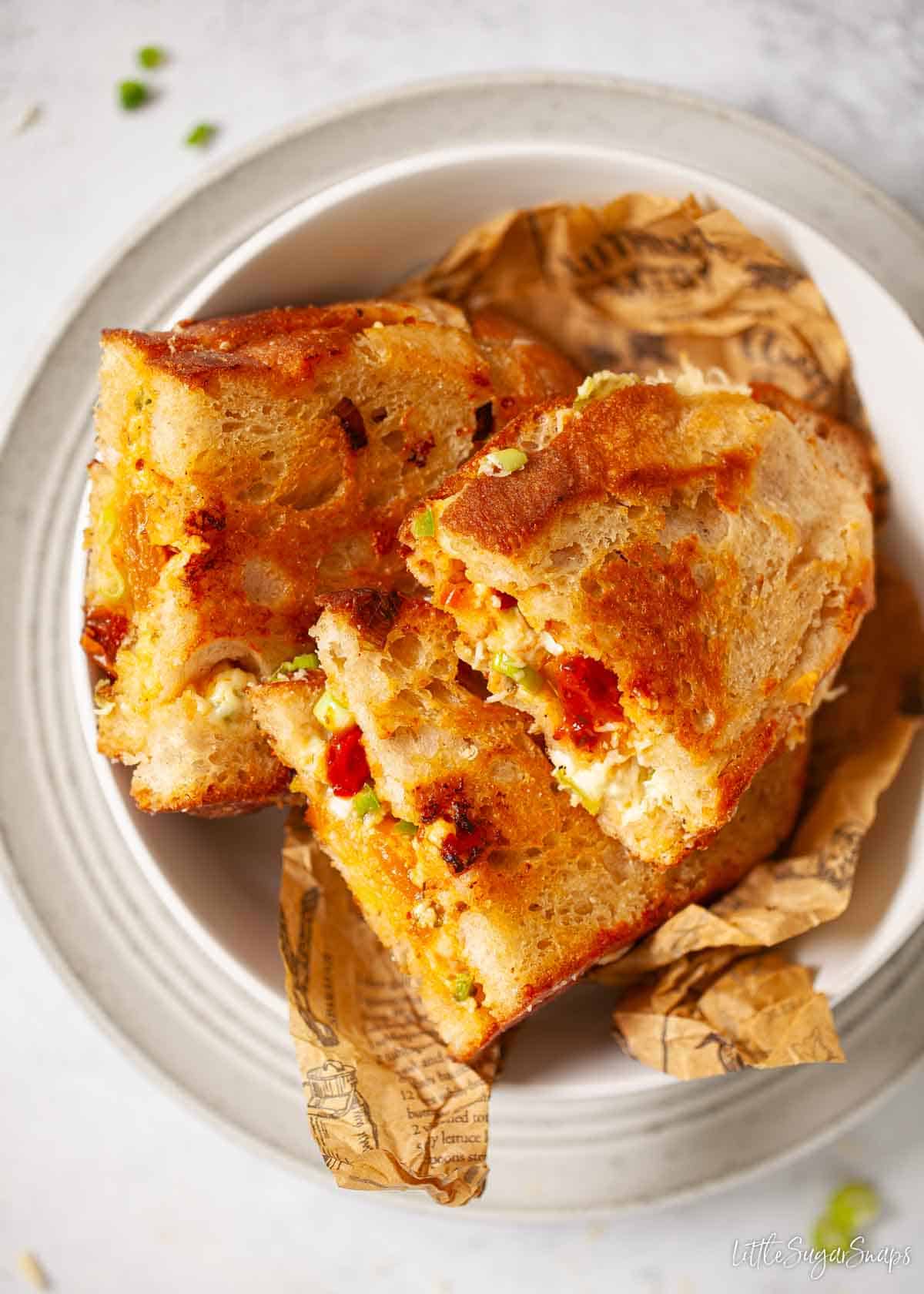 Chilli cheese toasties cut in half and served in a bowl.