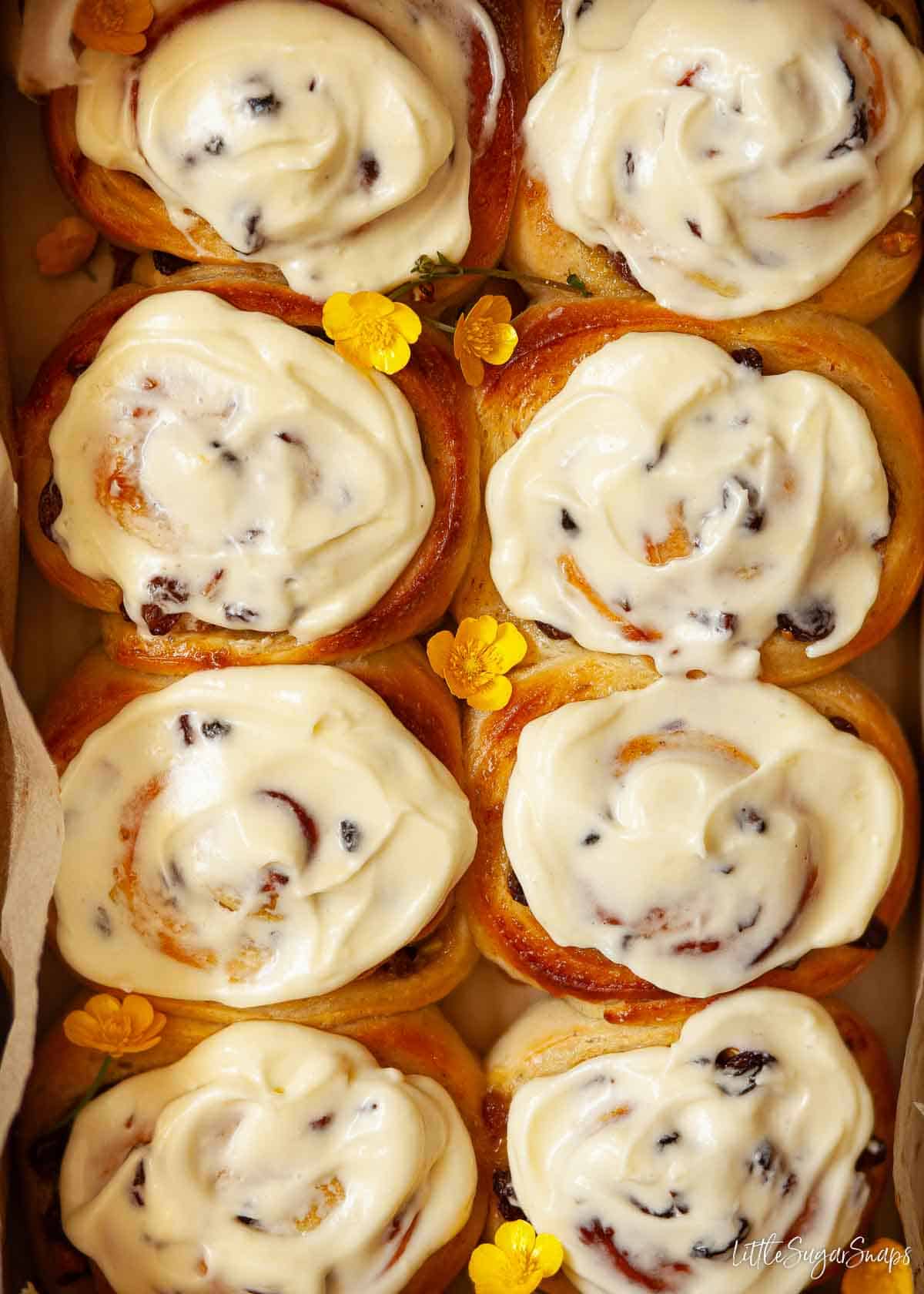 Eight lemon buns topped with lemon cream cheese frosting.