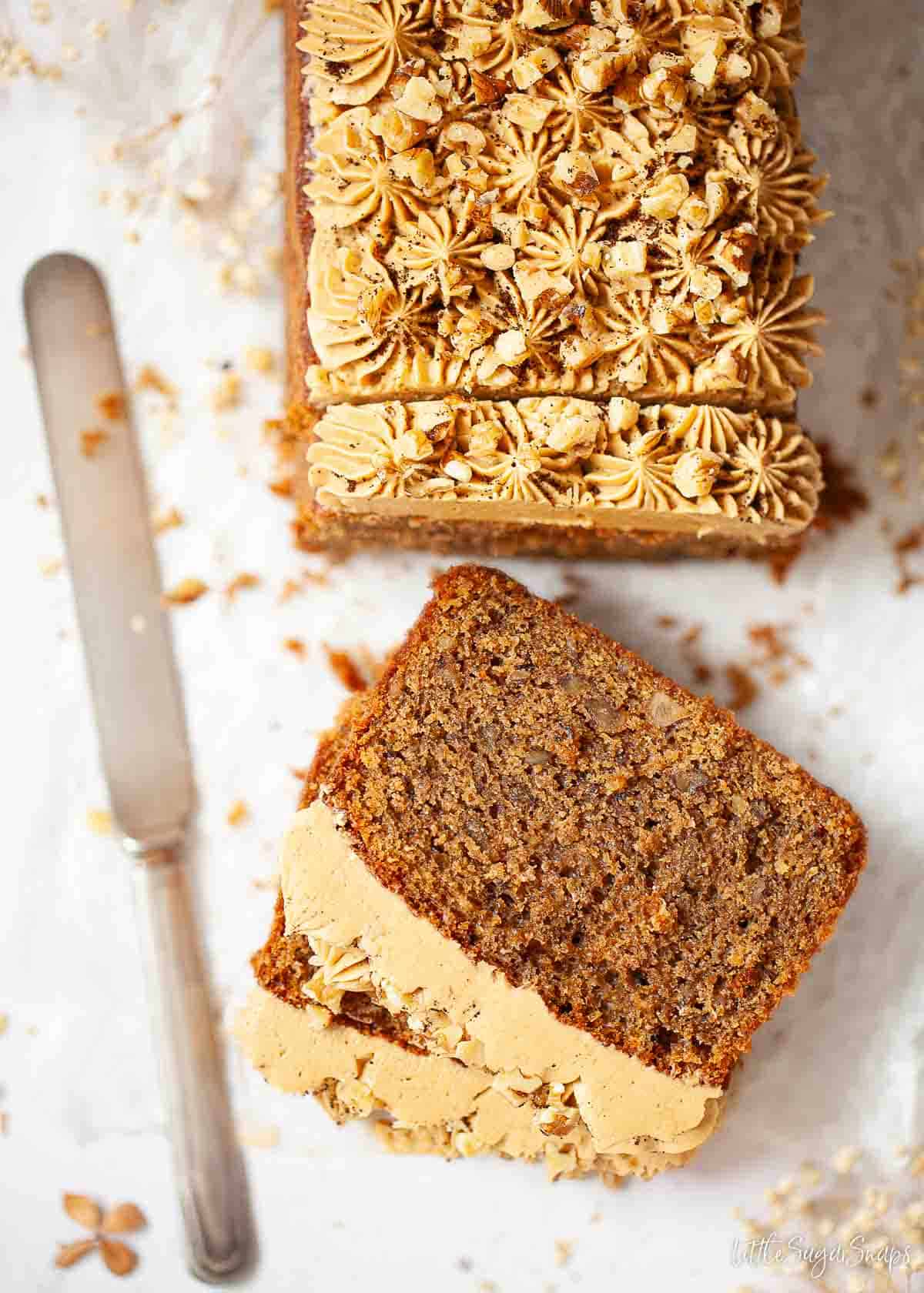 Overhead view of a coffee walnut loaf partially sliced.