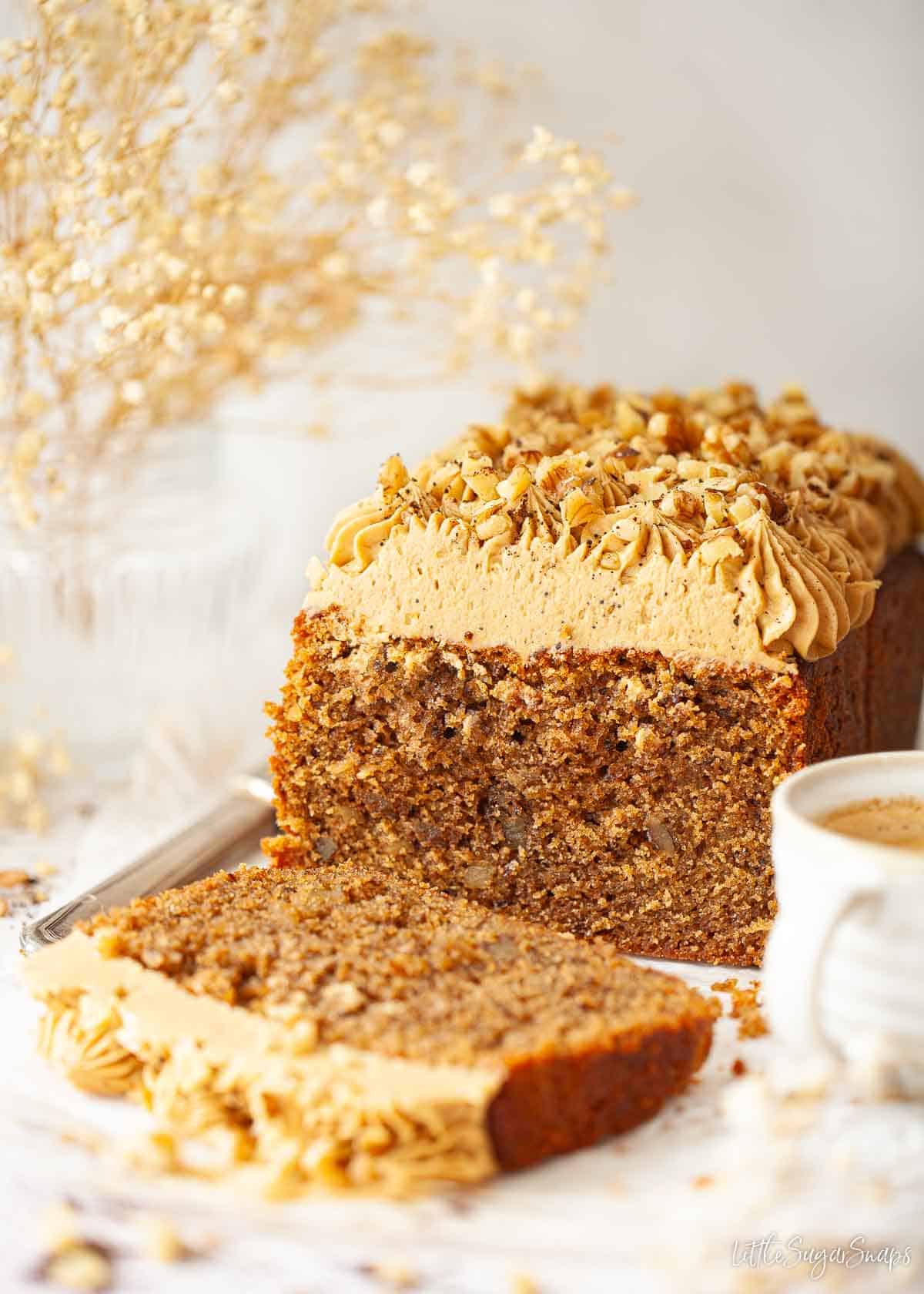 A partially sliced coffee loaf cake topped with coffee buttercream.