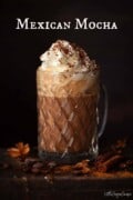 Labelled image of a Mexican mocha topped with whipped cream, chilli powder and grated chocolate.