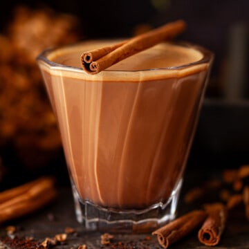 Close up of a Mexican mocha chocolate and coffee drink topped with a cinnamon stick.