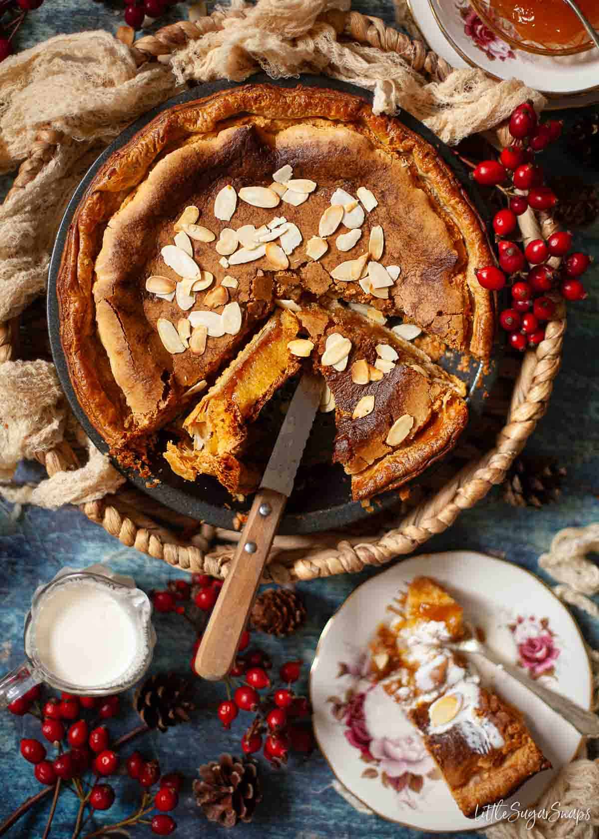 A part sliced Derbyshire Bakewell pudding with one slice on its side to reveal the centre.