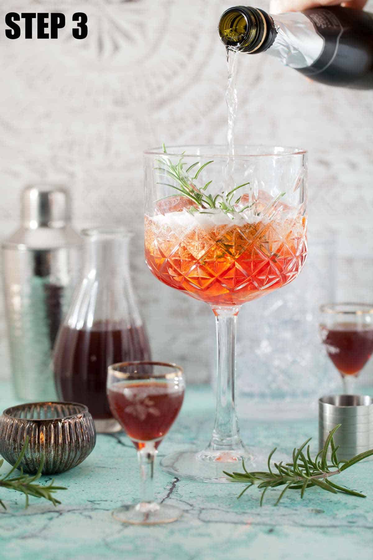 Prosecco being poured over alcohol in a glass.