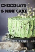 Labelled mint chocolate cake on a stand with flowers on the top.