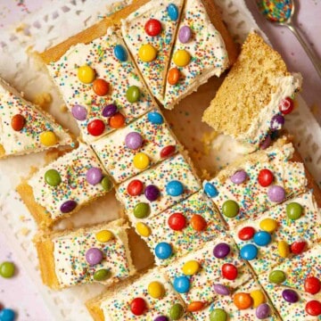 Close up of birthday tray bake cake with buttercream, sprinkles and colourful chocolate candies.