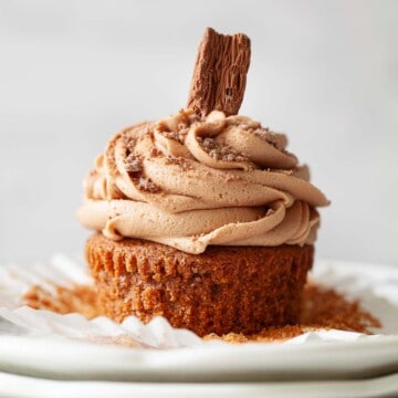 Close up of a hot chocolate cupcake with milk chocolate buttercream and Cadbury Flake.