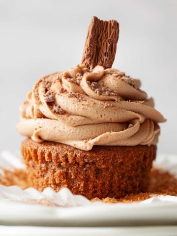 Close up of a hot chocolate cupcake with milk chocolate buttercream and Cadbury Flake.