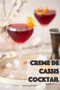 Two creme de cassis cocktails in Nick & Nora glasses garnished with orange zest with text overlay.