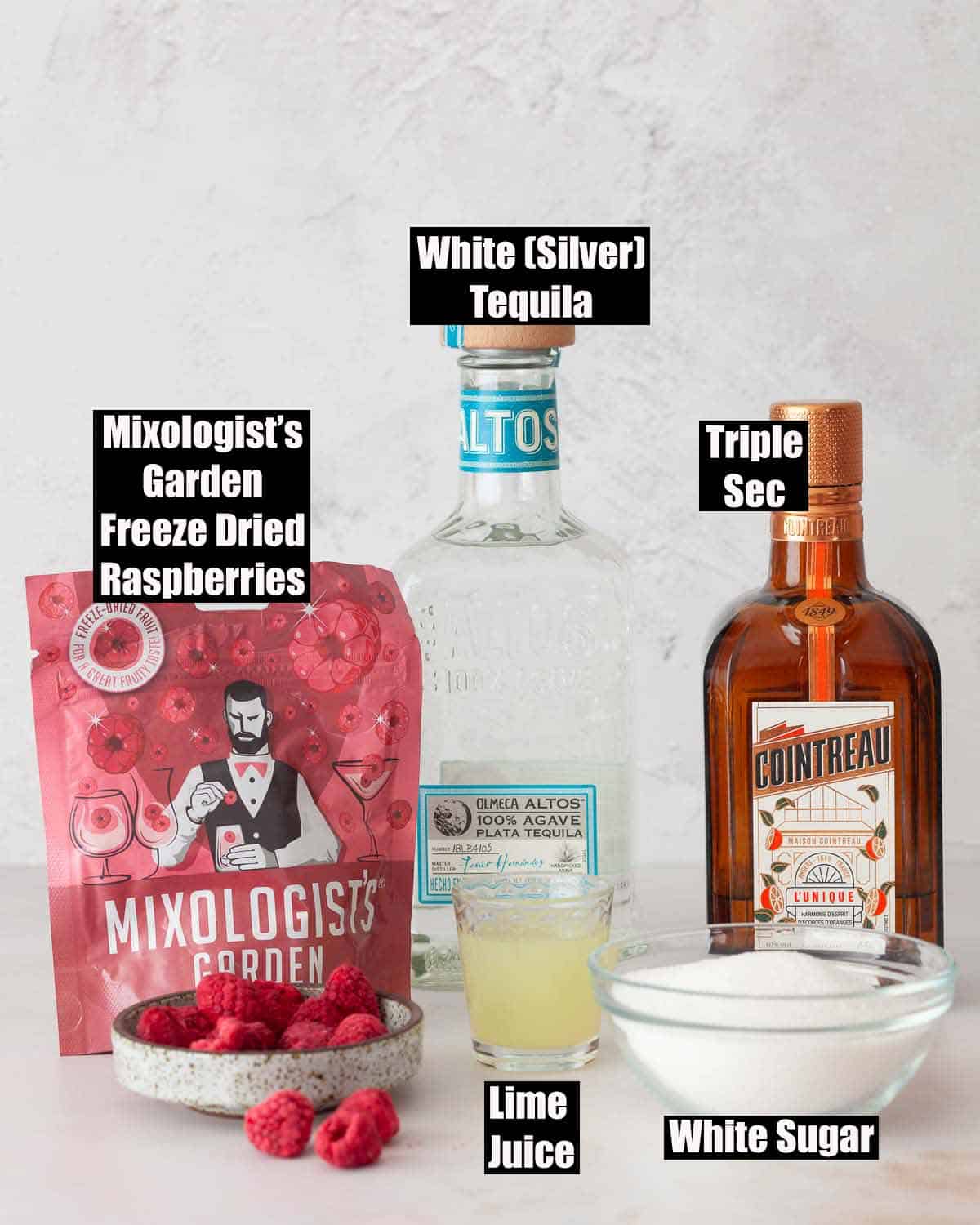 Ingredients for a cocktail made with freeze dried raspberries with text overlay.