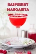 Raspberry margarita in a glass rimmed with crushed freeze dried fruit with text overlay.