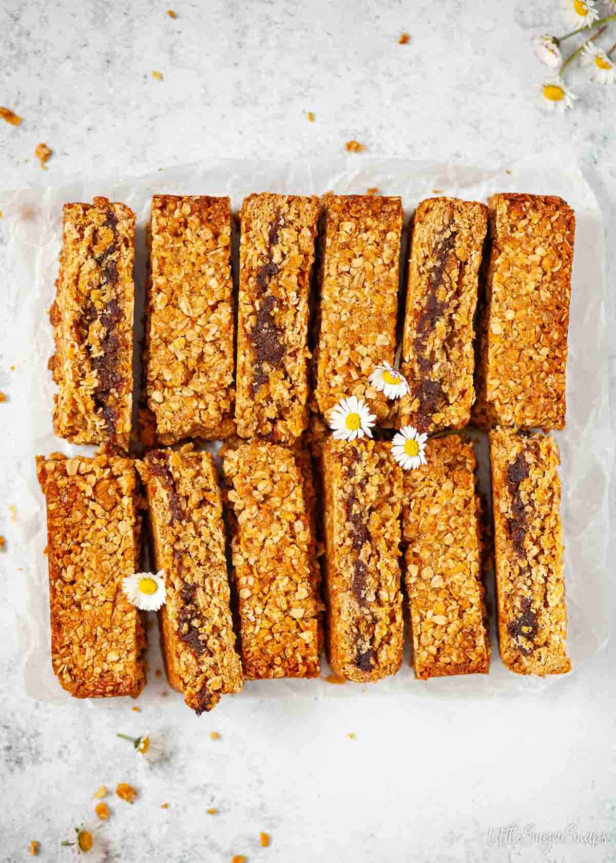 Twelve oat and date bars on a worktop.