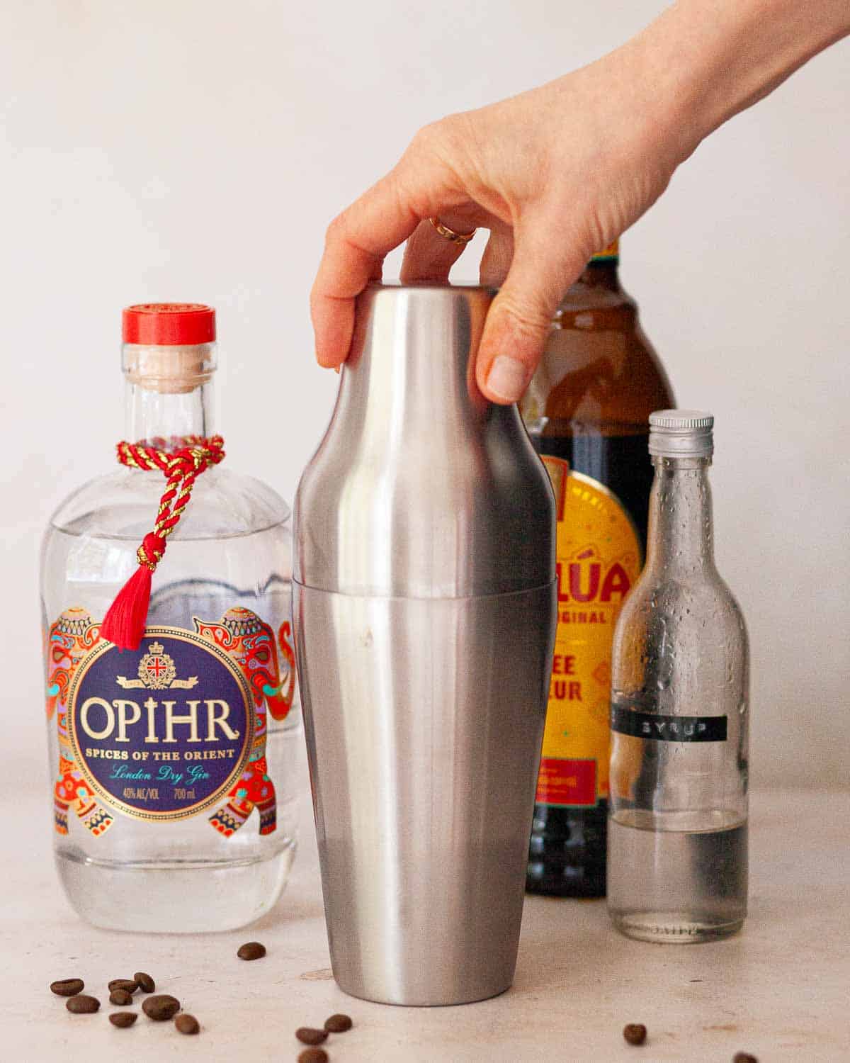 A person securing the lid of a cocktail shaker.