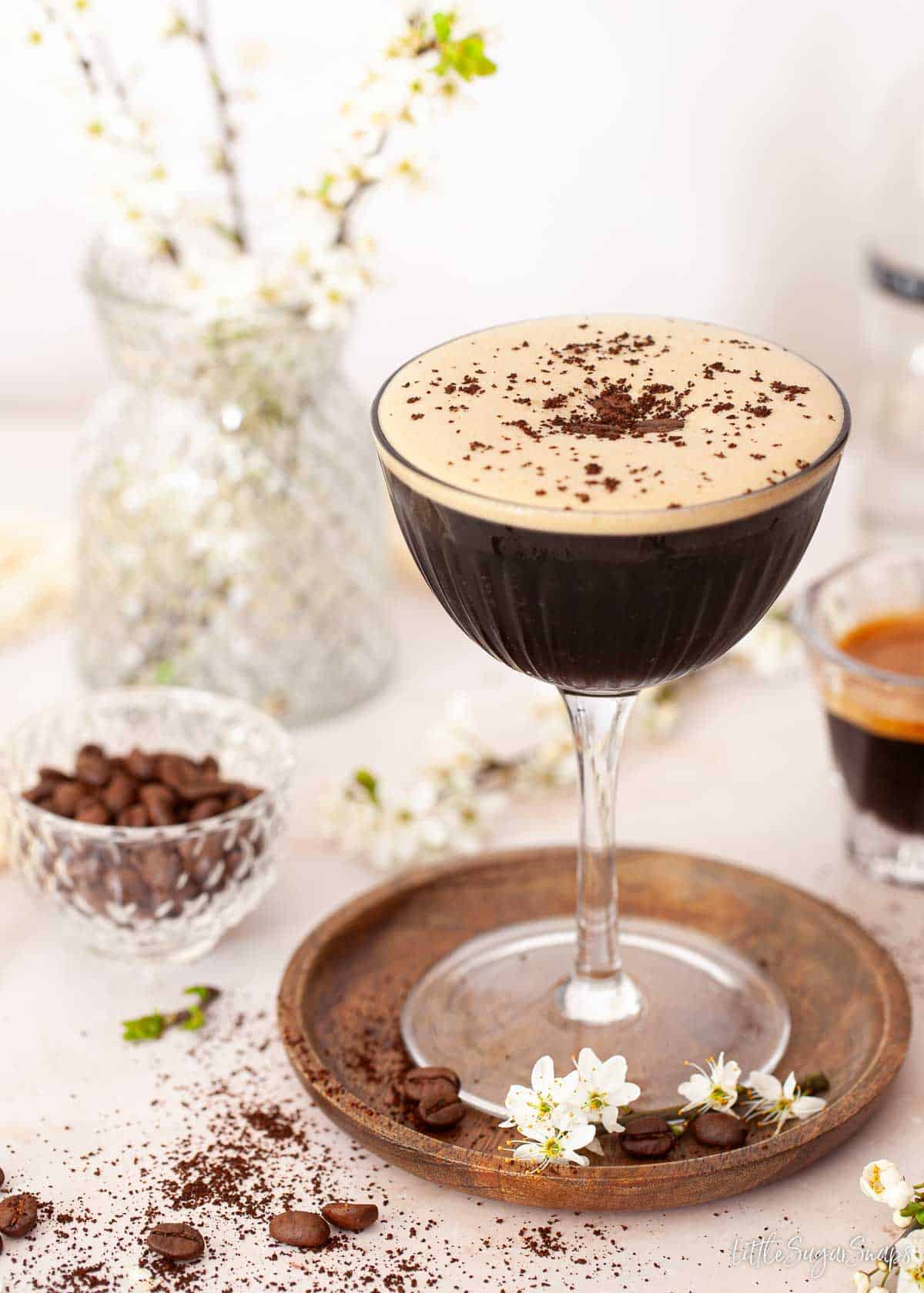 A ginspresso martini topped with coffee beans and ground coffee.