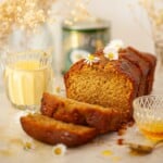 Sliced golden syrup cake with a tin of Lyle's golden syrup in the background.