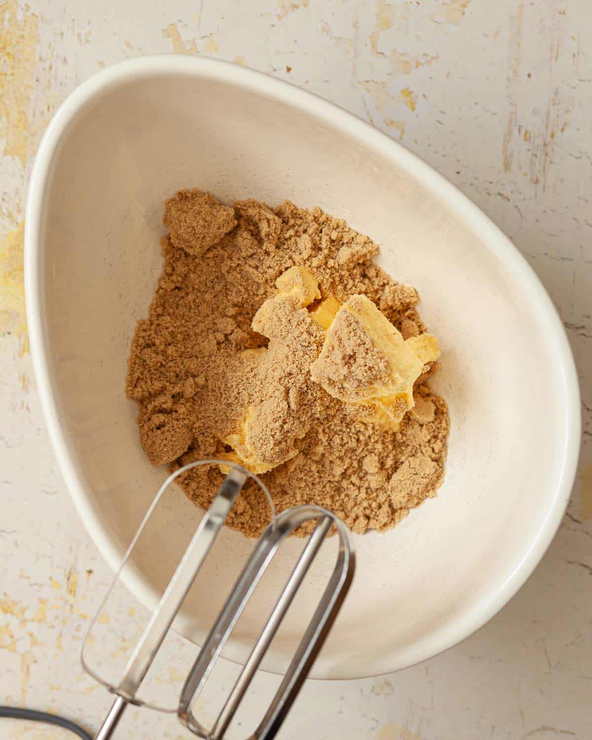 Butter and light brown sugar in a mixing bowl before being mixed together.