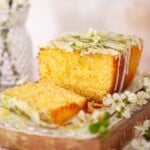 Close up of a cut into cake with lime drizzle and lime icing toppings.