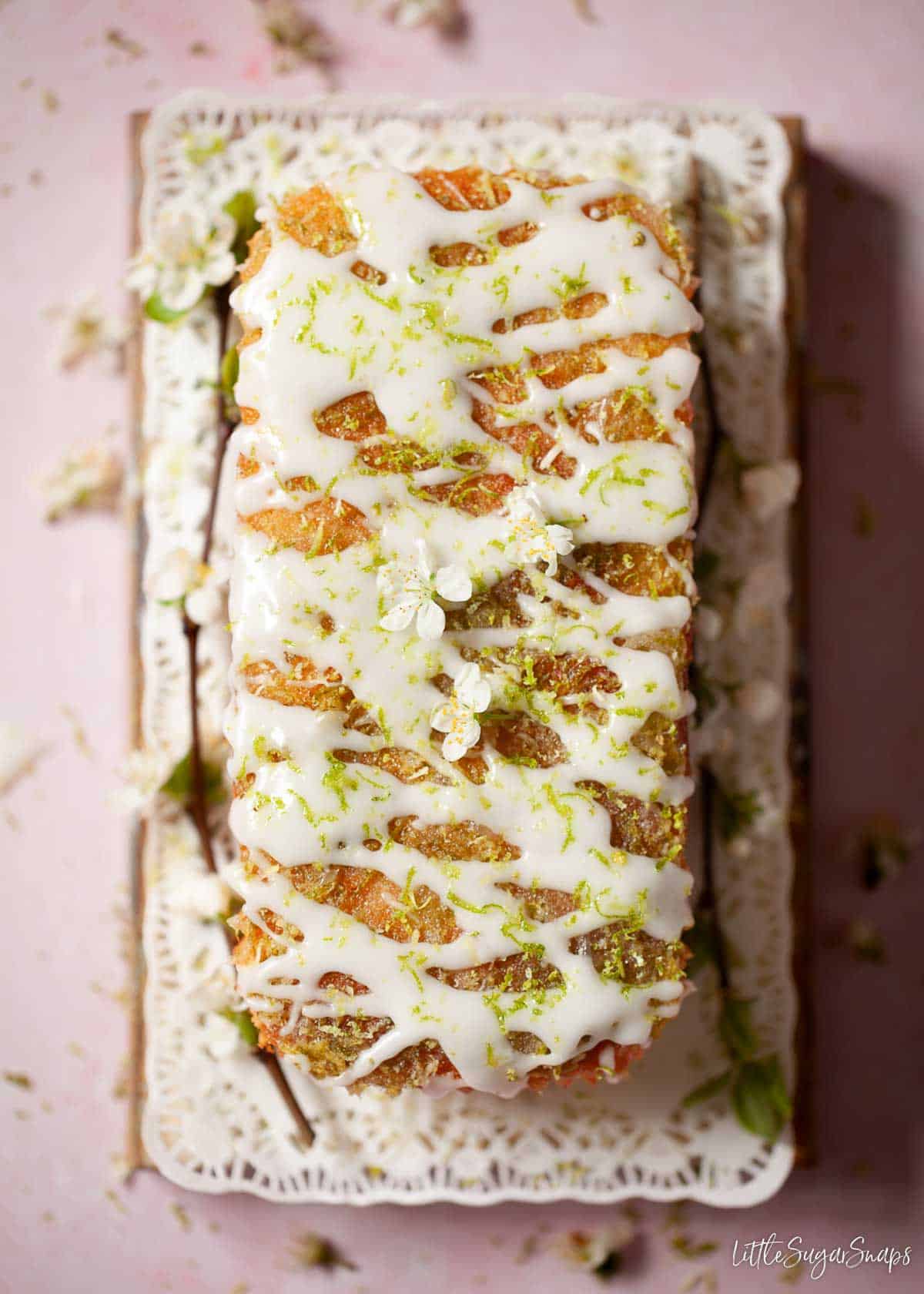 Overhead view of a lime cake with drizzle syrup and glace icing on the top.