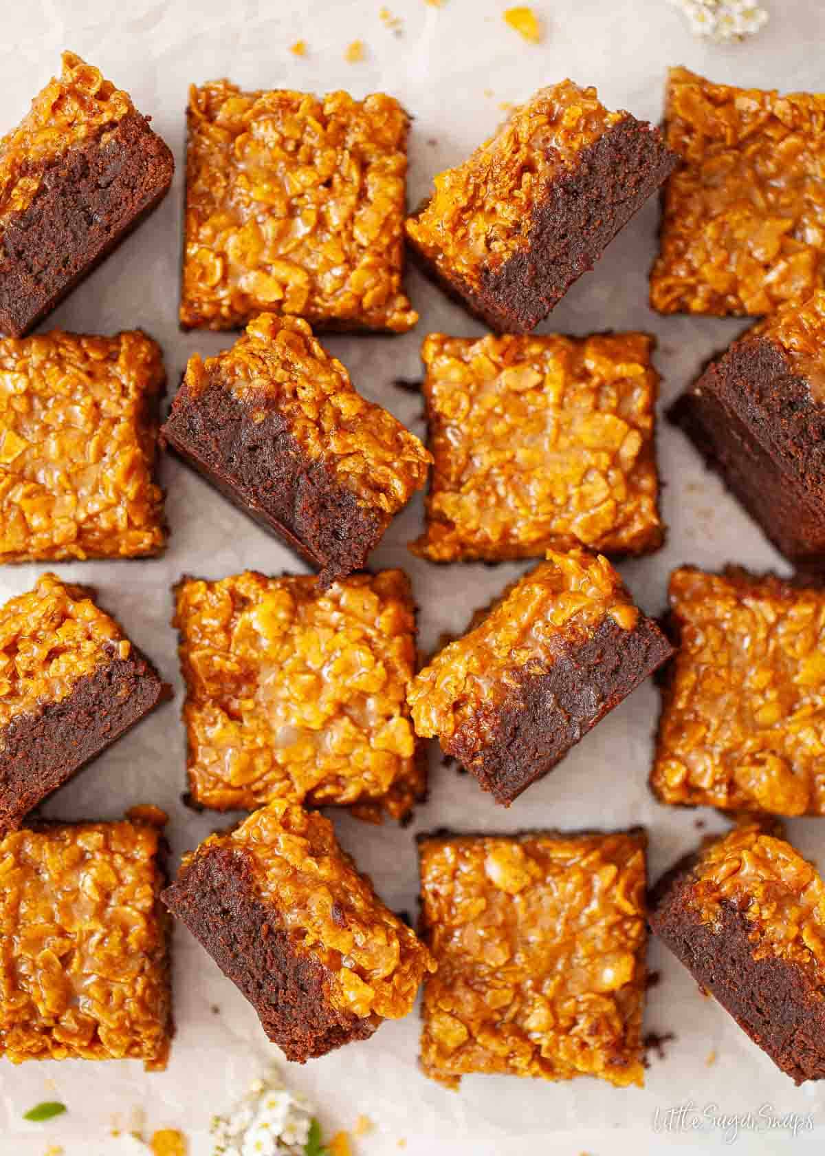 Squares of caramel cornflake brownie with a few on their side to reveal the layers.