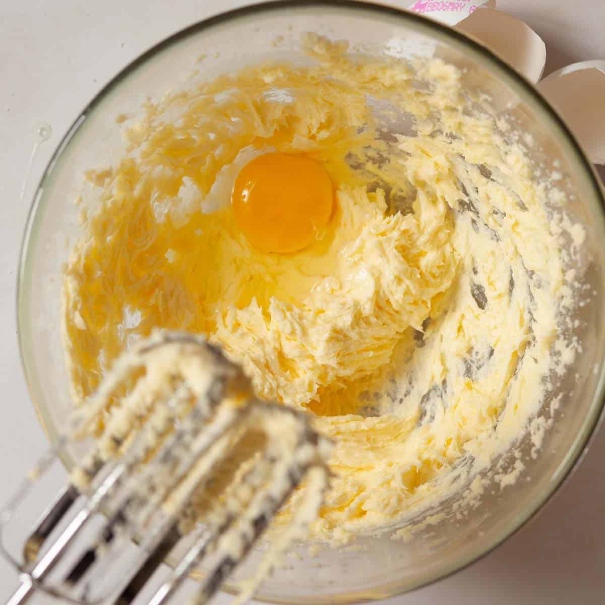 An egg being added to frangipane batter.