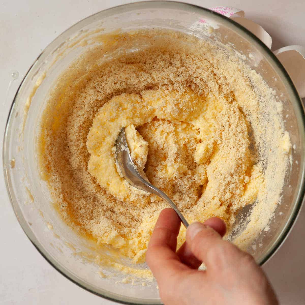 Ground almonds being mixed into frangipane batter.