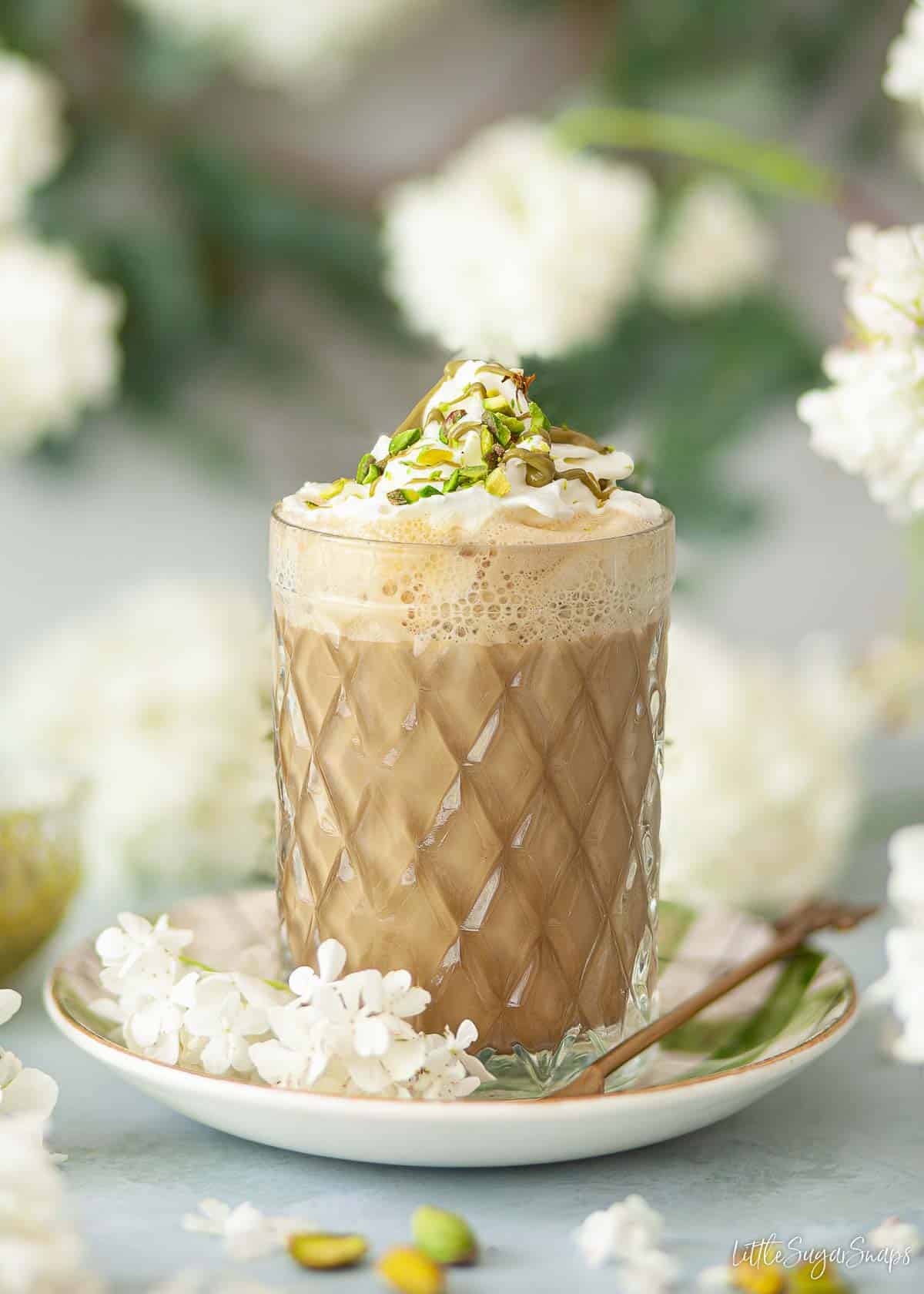 Pistachio latte with whipped cream, pistachio sauce and chopped pistachio nuts.
