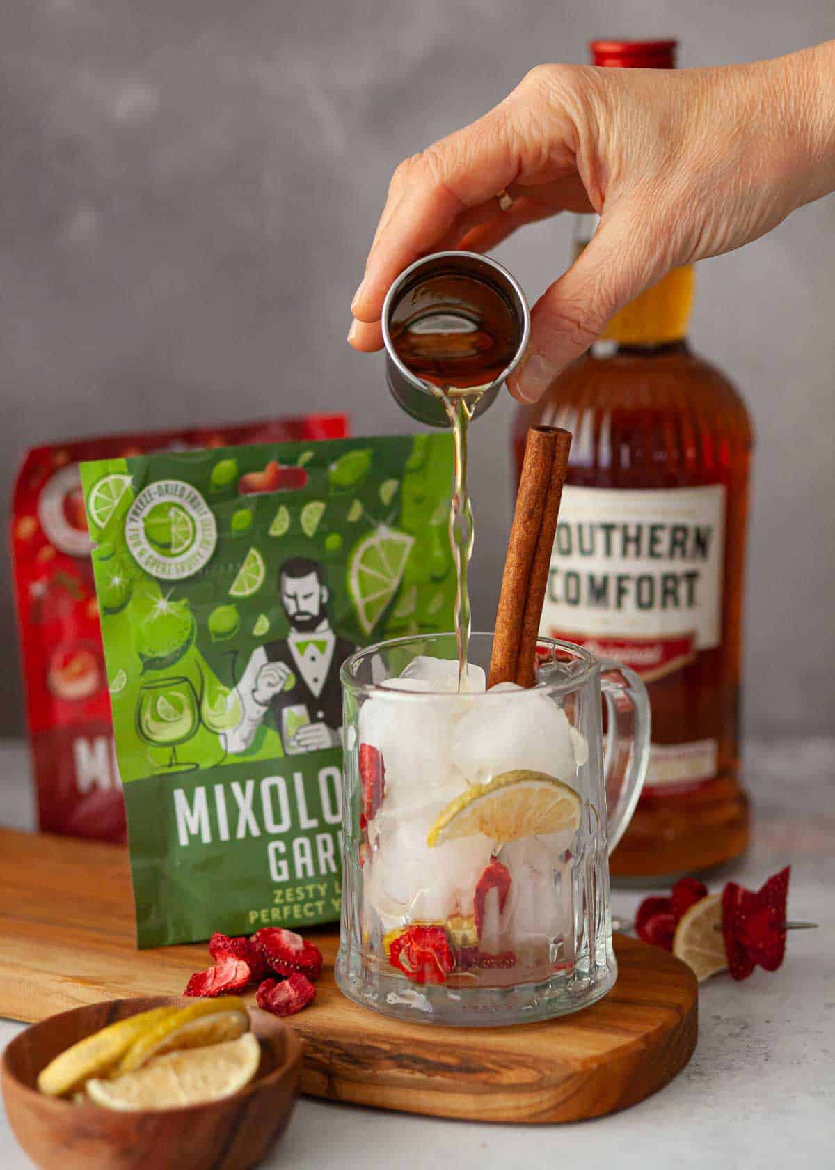 Southern Comfort being poured into a glass tankard filled with ice and fruit pieces.