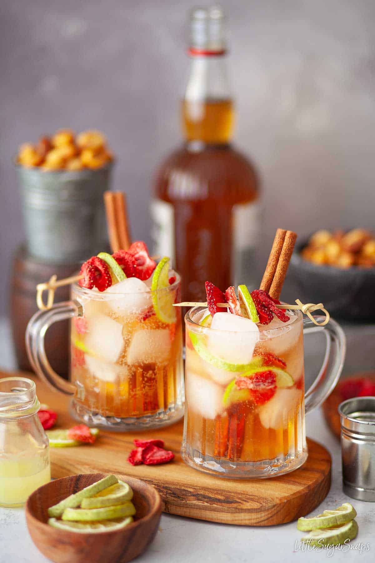 Southern Comfort cocktail garnished with cinnamon and freeze-dried fruit on bamboo skewers.