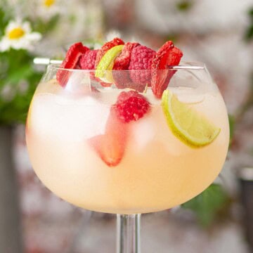 A close-up of agin English Garden cocktail garnished with freeze-dried fruit.