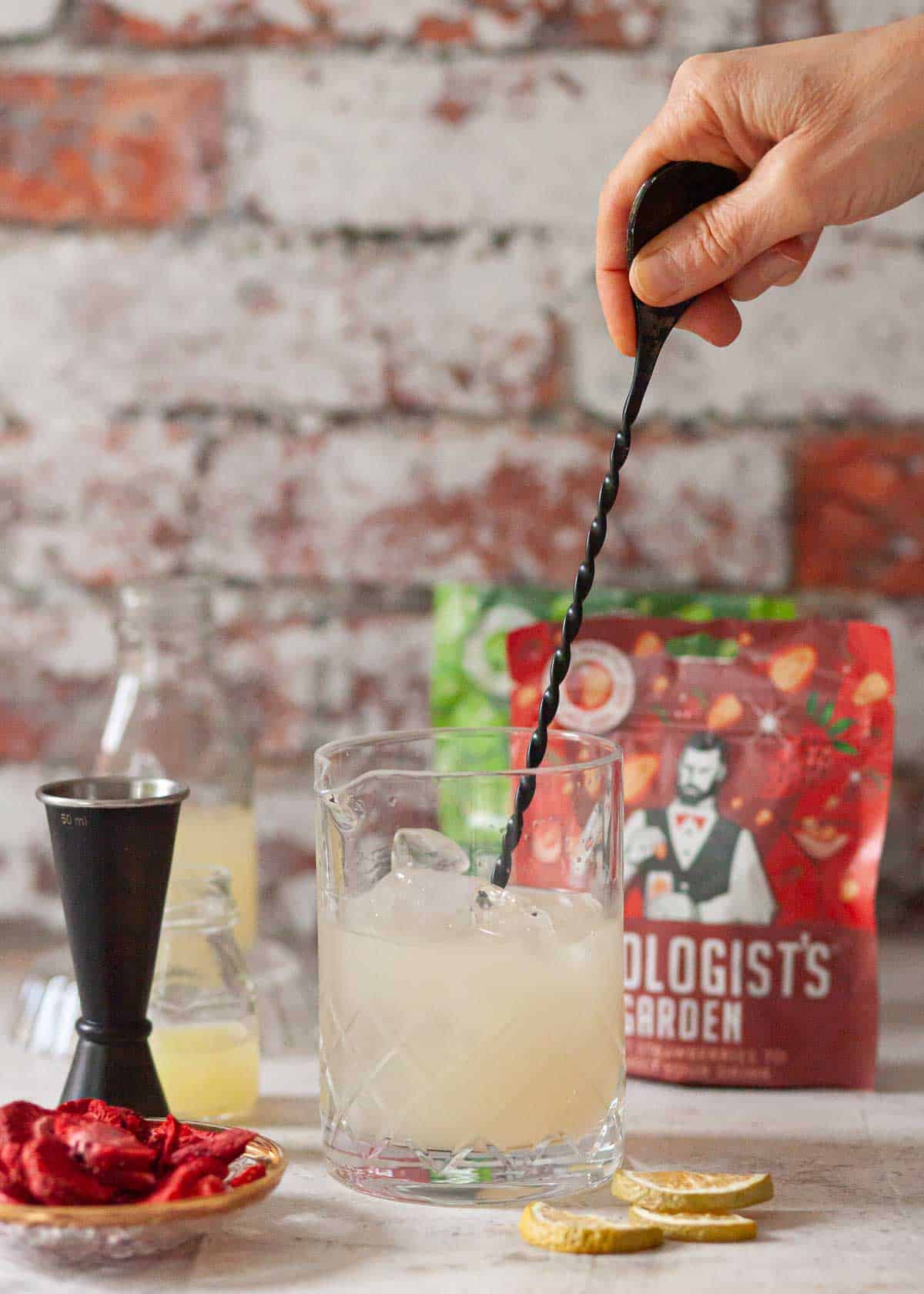 A person stirring liquid in a bar jub.