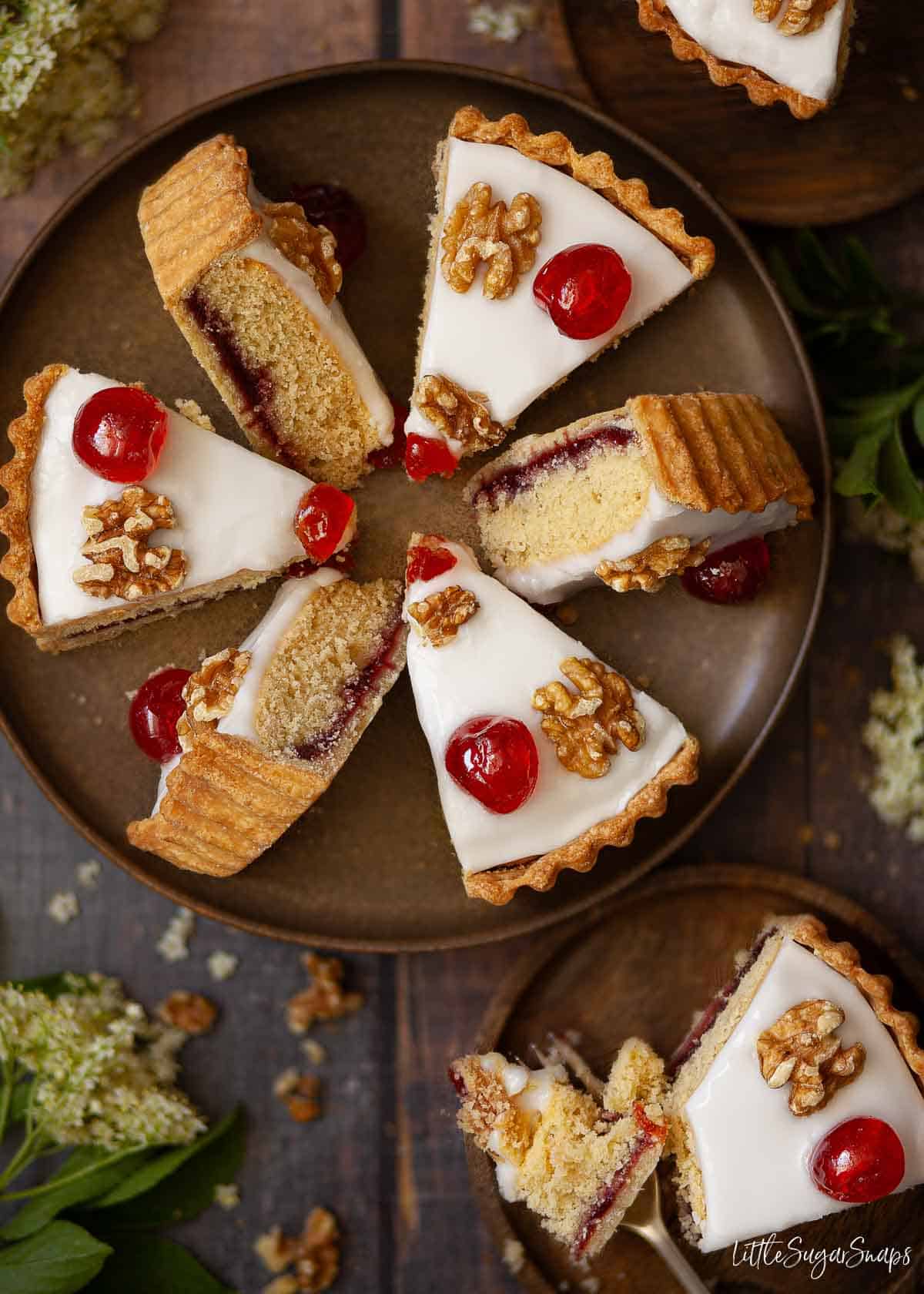 Slices of sponge cake with pastry base and a layer of jam presented on a plate.