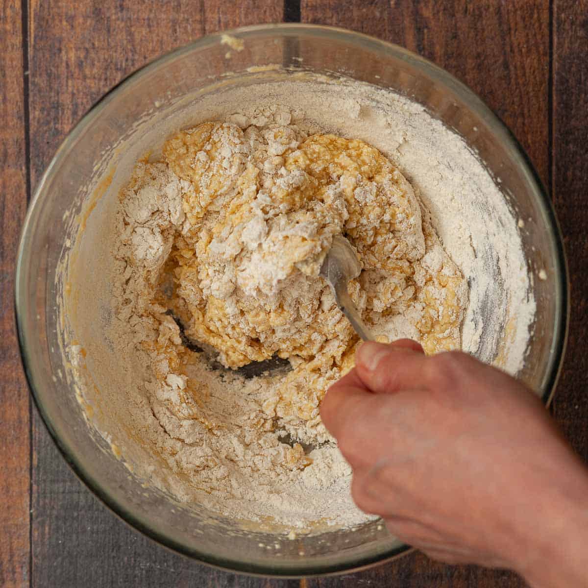 A person mixing flour into cake batter