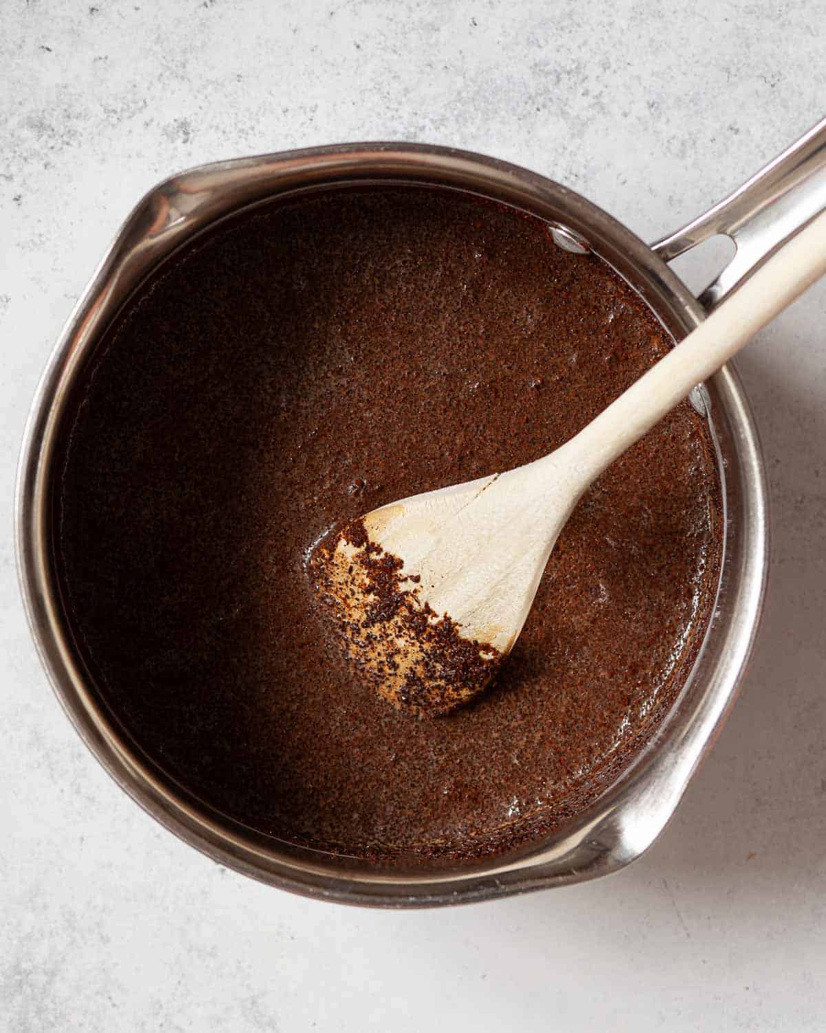 Ground coffee in a pan of milk.