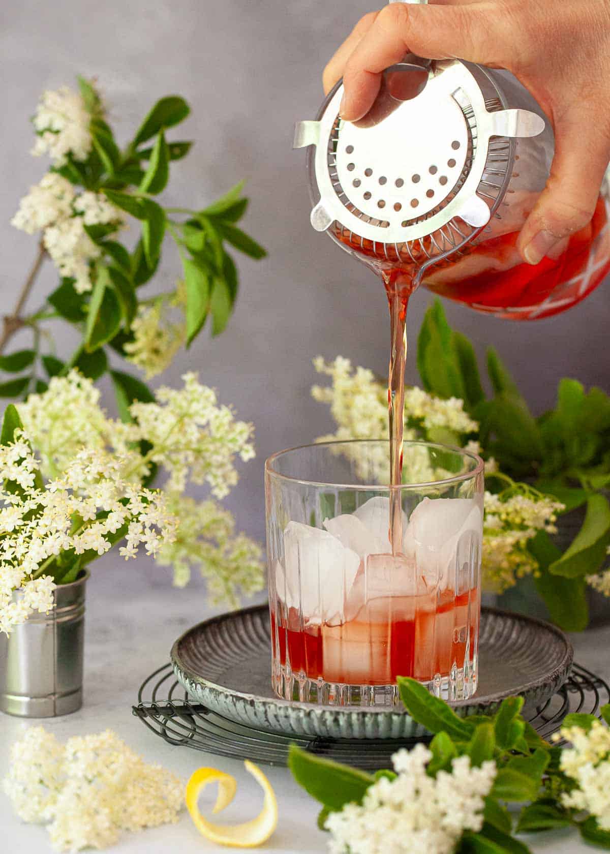 A Campari variation being poured into a glass over ice.