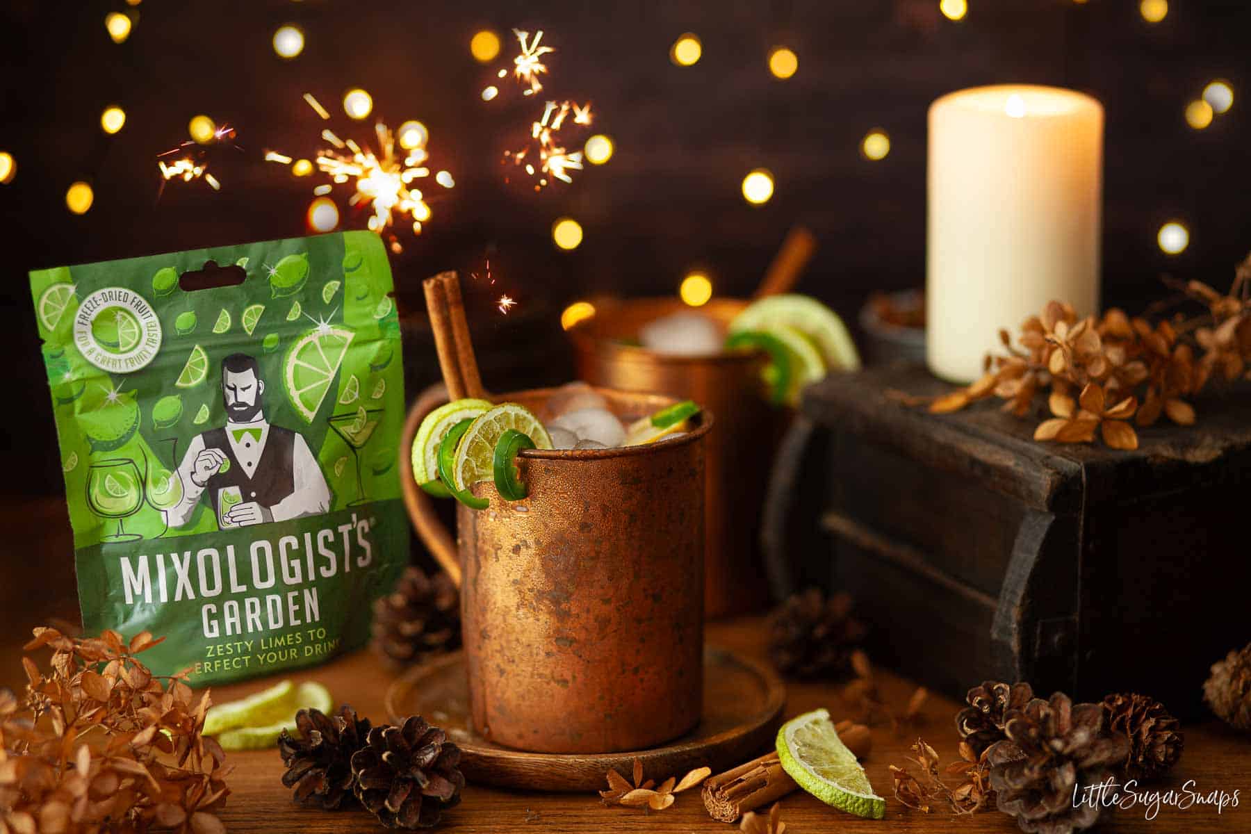 Tequila mule cocktails in copper mugs with cinnamon, lime and chilli and packet of lime slices.